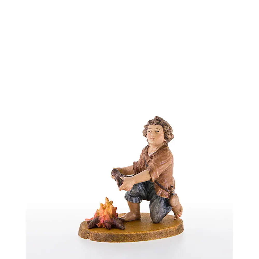 Bub kniend neben Feuerstelle